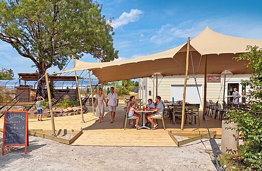 Schaduwrijk terras restaurant en bar op camping CLICOCHIC Trois Chênes.