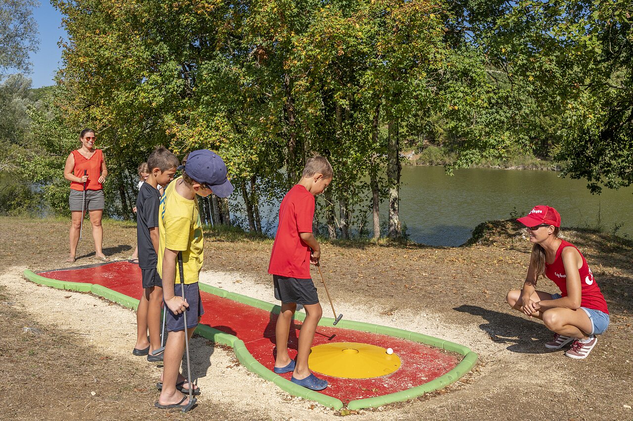 Kinderen spelen minigolf bij meer op camping CAPFUN Ullule Tournon d'Agenais.