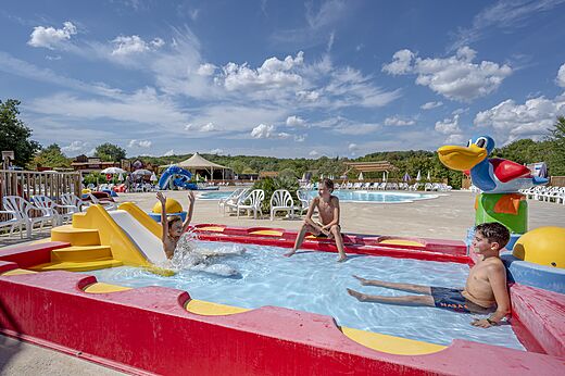 Kinderen spelen in de waterspeeltuin met glijbaan op camping CAPFUN Ullule in Tournon d'Agenais (47).