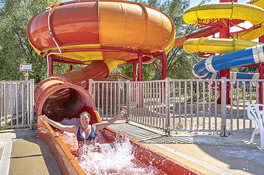 Lachende vrouw glijdt van een gigantische waterglijbaan op camping CAPFUN Ullule in Tournon d'Agenais (47).