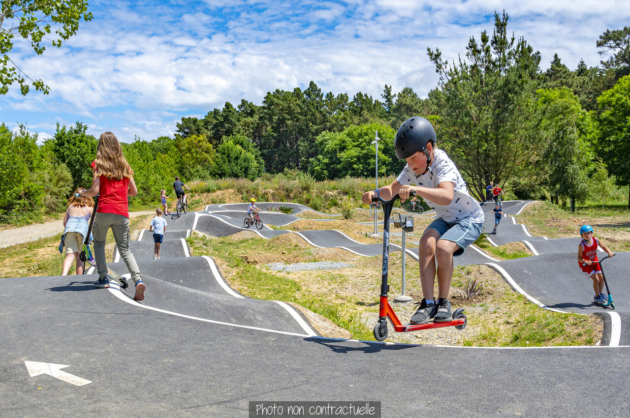 Pump track met kinderen op scooters en fietsen op camping CAPFUN Val d'Authie.