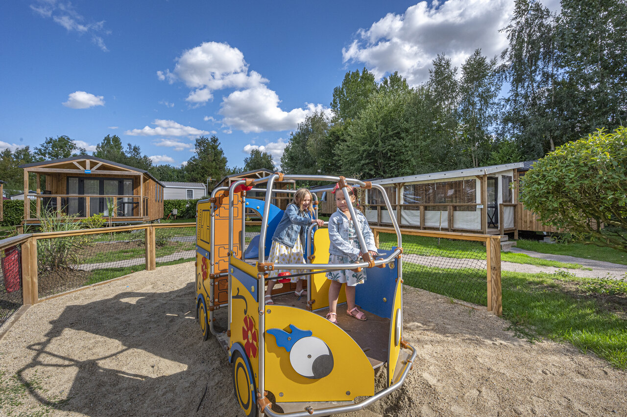 Kinderen spelen op speeltoestel, stacaravans op camping CAPFUN Val d'Authie in Villers sur Authie.