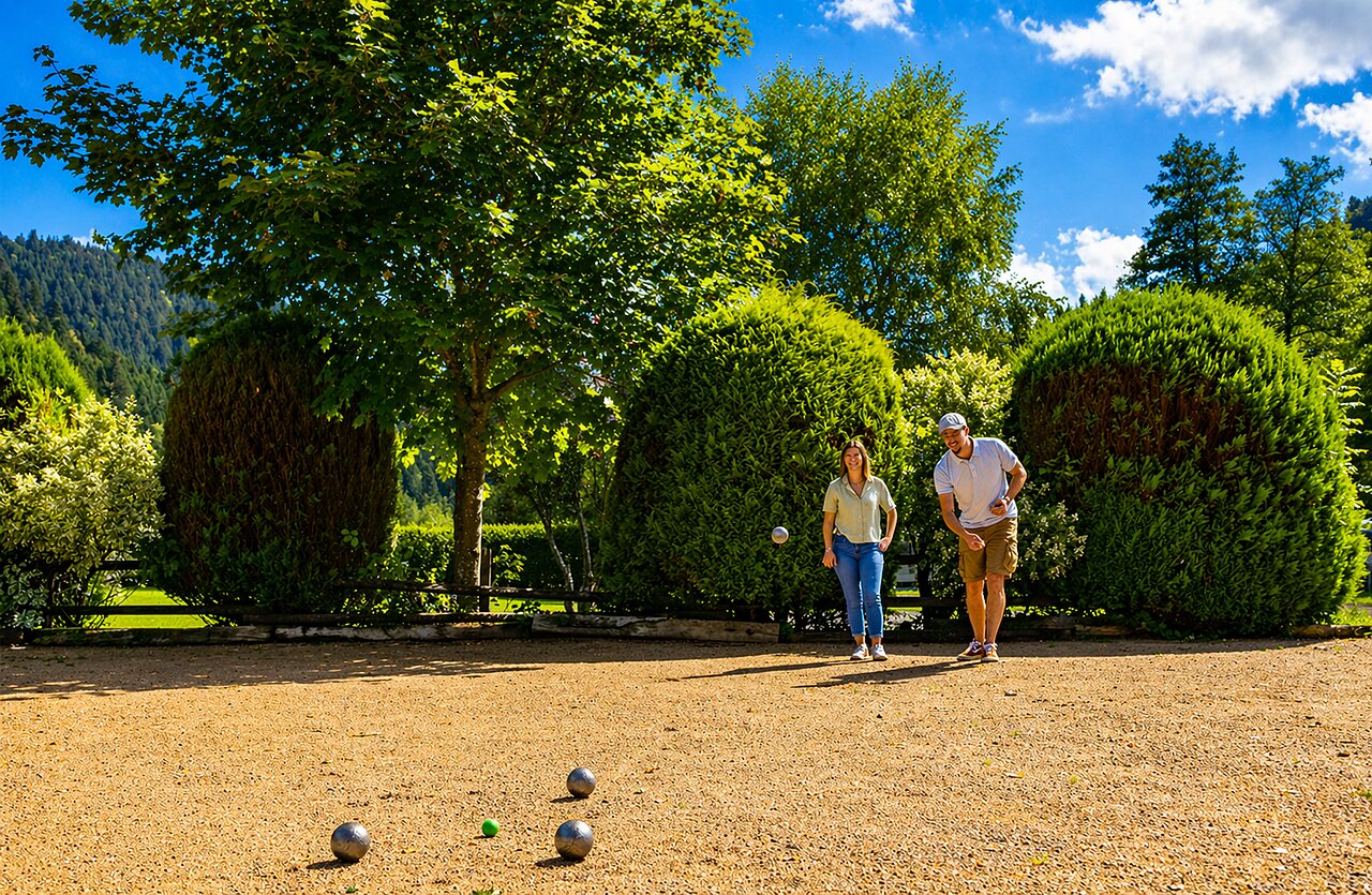 Koppel speelt petanque op terrein camping CLICOCHIC Verte Vall�e XONRUPT LONGEMER.