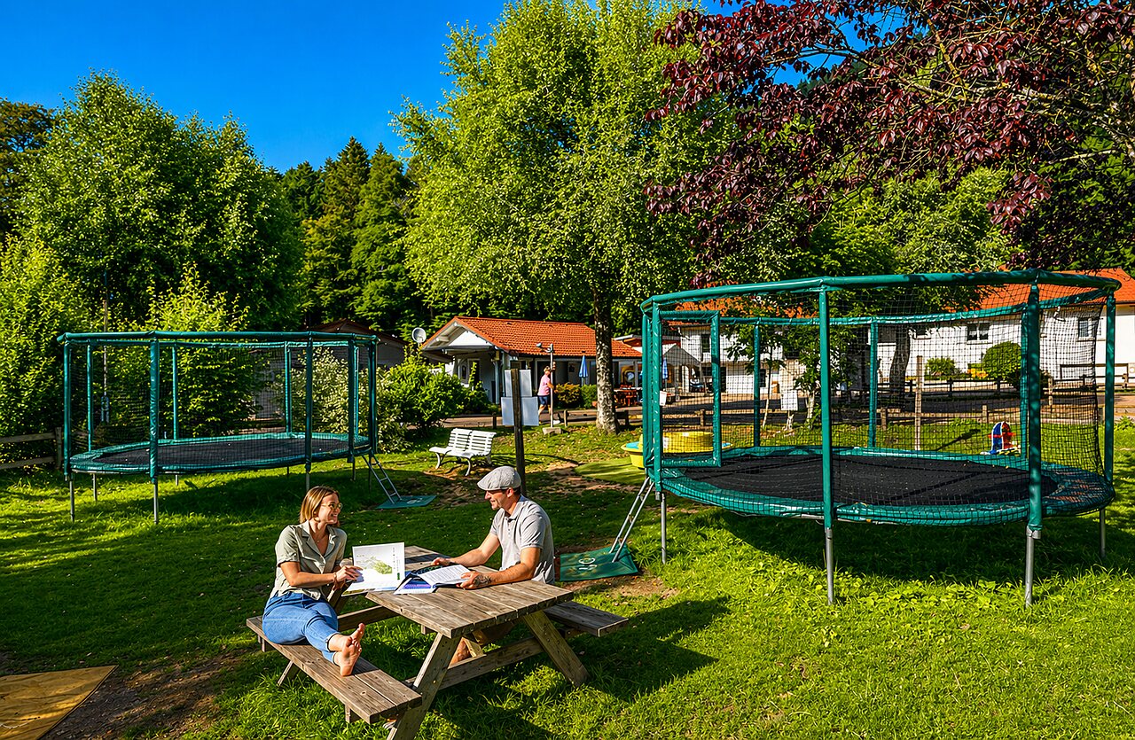 Twee trampolines en stel aan picknicktafel op camping CLICOCHIC Verte Vall�e in XONRUPT LONGEMER.