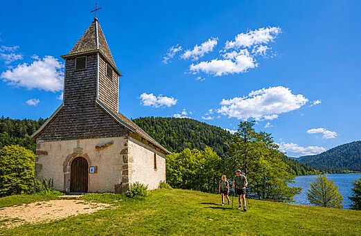 Kapel, wandelaars en bergmeer bij camping CLICOCHIC Verte Vall�e XONRUPT LONGEMER.