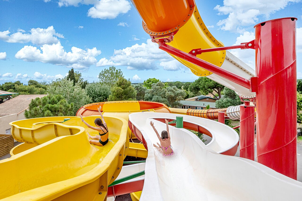 Twee kinderen op kleurrijke waterglijbanen op camping CAPFUN Vignes d'Or in Serignan.