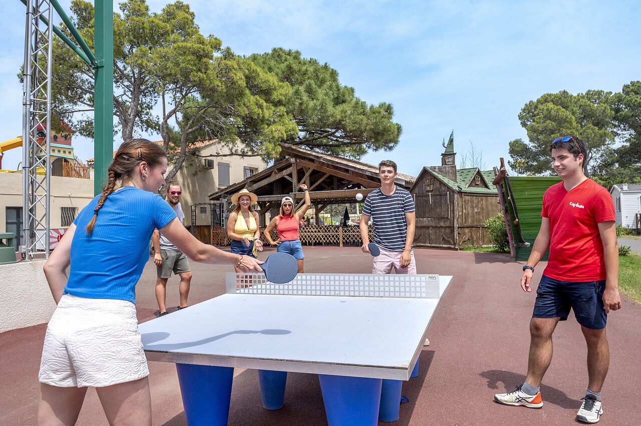 Jongeren spelen tafeltennis buiten op camping CAPFUN Vignes d'Or in Serignan.