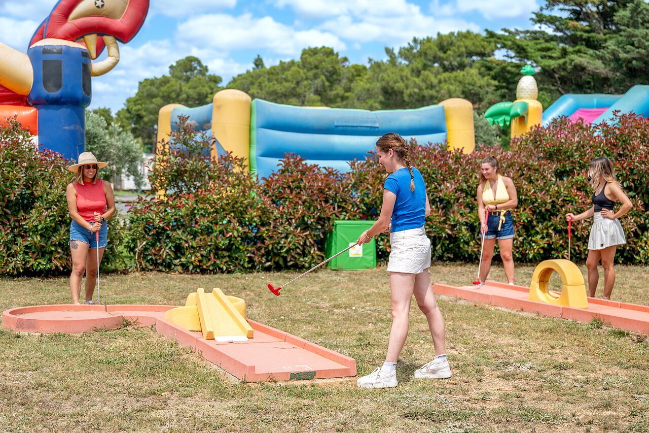 Vrouwen minigolf spelend met opblaasbare spellen op camping CAPFUN Vignes d'Or in Serignan.