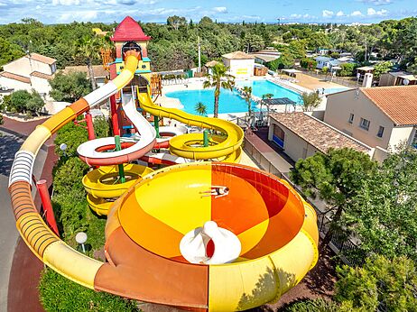 Gigantische waterglijbanen en zwembad vanuit de lucht op camping CAPFUN Vignes d'Or Serignan.