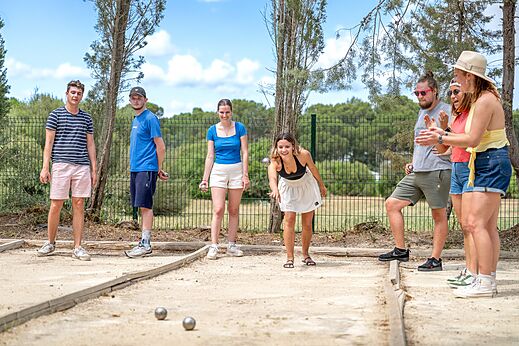 Jongeren spelen jeu de boules op een speciale baan op camping CAPFUN Vignes d'Or in Serignan.