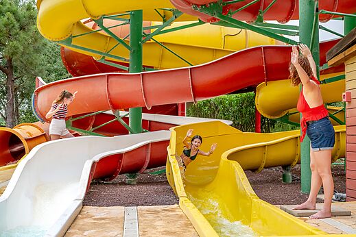 Kleurrijke waterglijbanen en kinderen op camping CAPFUN Vignes d'Or in Serignan.
