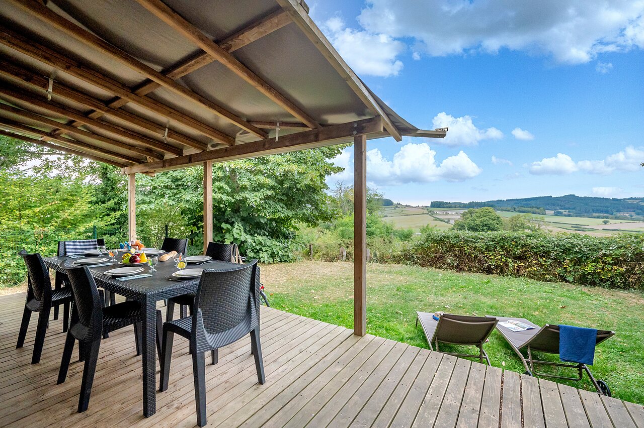 Overdekt terras, eettafel, natuurzicht op camping CLICOCHIC Village des Meuniers in Dompierre-les-Ormes (71).
