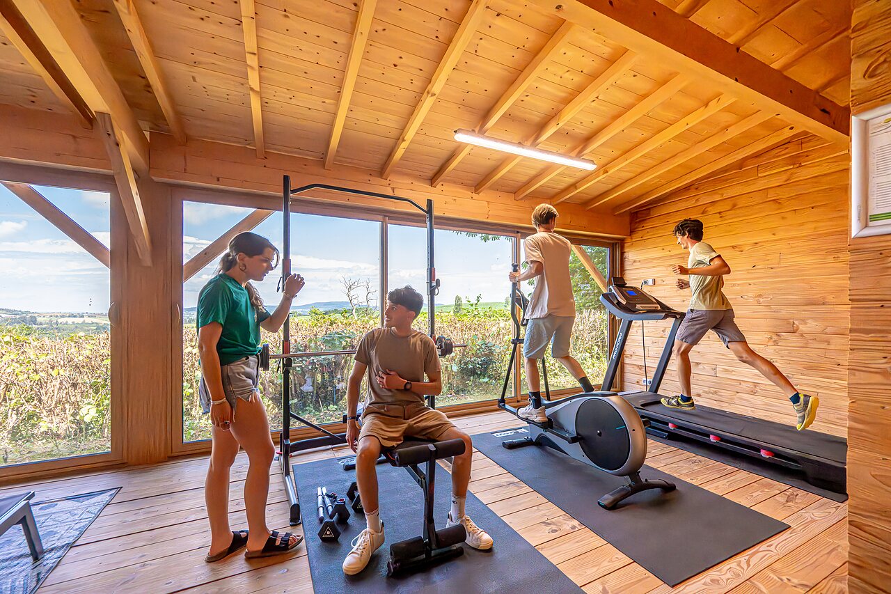 Moderne fitnessruimte met sportuitrusting op camping CAPFUN Cenic in Dompierre-les-Ormes.