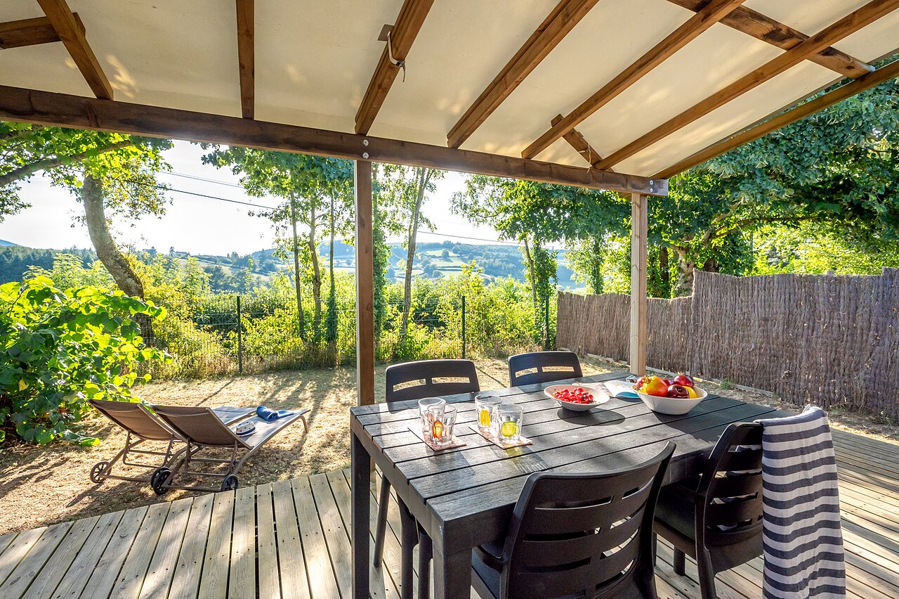 Terras van stacaravan met tafel en uitzicht op de natuur op camping CLICOCHIC Village des Meuniers in Dompierre-les-Ormes (71).