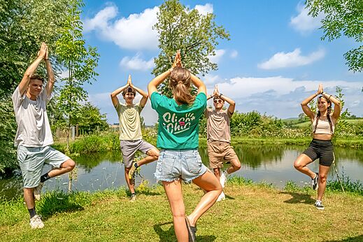 Groepsyoga bij een vijver op camping CLICOCHIC Village des Meuniers (71).