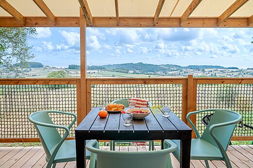 Ingerichte terras met tafel en panoramisch uitzicht op camping CLICOCHIC Village des Meuniers in Dompierre-les-Ormes (71).