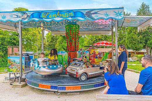 Kinderdraaimolen met auto's en helikopter op camping CAPFUN Le Village Parisien.