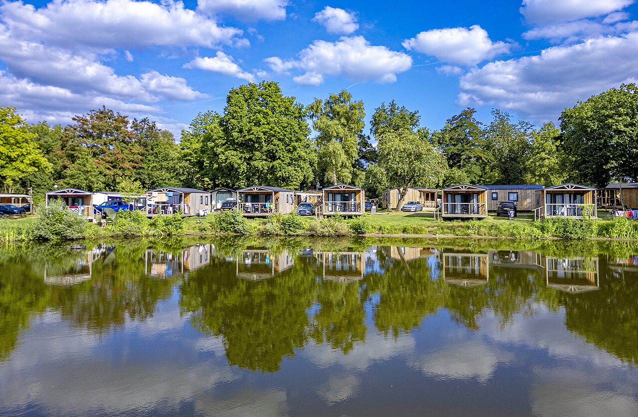 Houten stacaravans aan het meer, groene natuur, op camping CAPFUN Vlinderloo in Enschede.