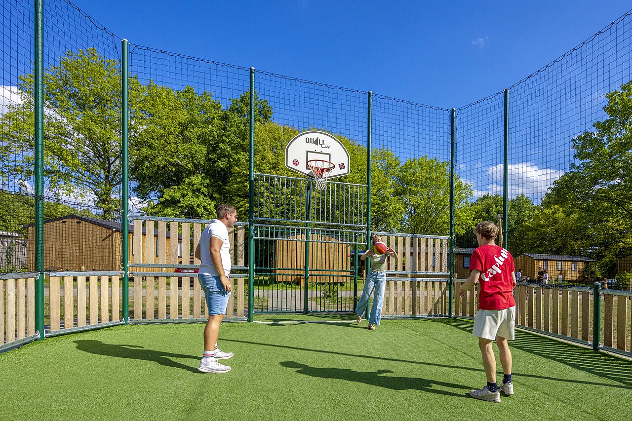 Multisportterrein met basketbalring en spelers op camping CAPFUN Vlinderloo in Enschede.