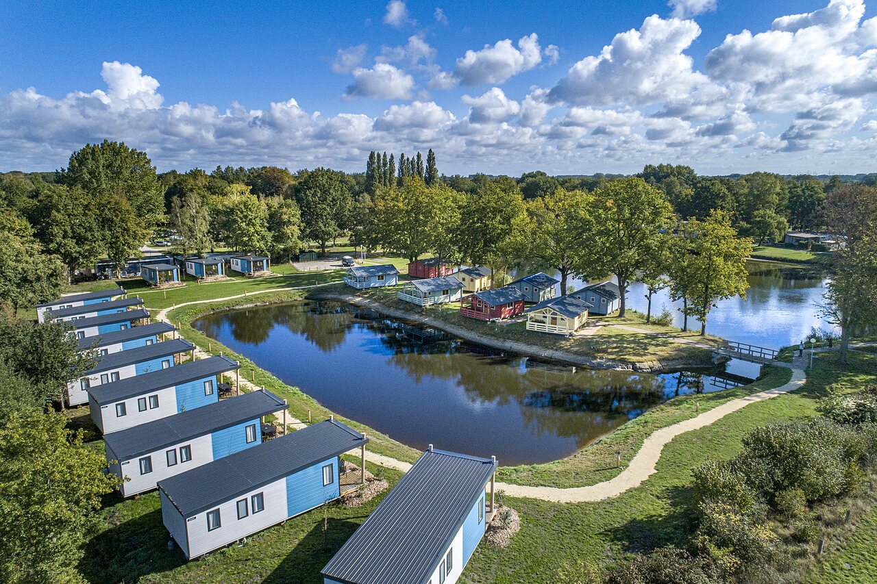 Luchtfoto van moderne stacaravans aan een vijver, op camping CAPFUN Vlinderloo in Enschede.