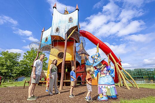 Grote kleurrijke speelstructuur met glijbaan en mascotte op camping CAPFUN Vlinderloo in Enschede.