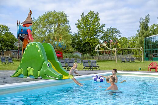 Kind op krokodillenglijbaan in het buitenzwembad op camping CAPFUN Vlinderloo in Enschede.