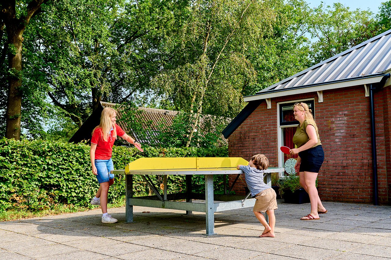 Familie speelt buiten tafeltennis op camping CAPFUN De Waldsang in Bakkeveen.