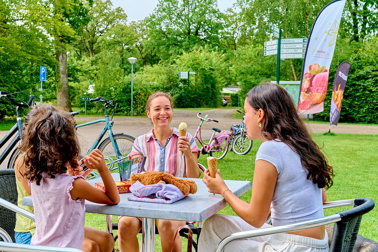 Lachende familie eet ijs op terras, fietsen, op camping CAPFUN De Waldsang in Bakkeveen