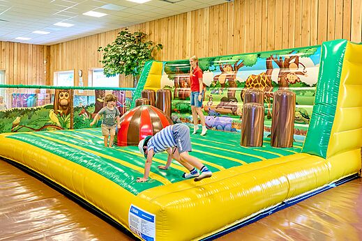 Kinderen spelen op een indoor springkasteel op camping CAPFUN De Waldsang in Bakkeveen.