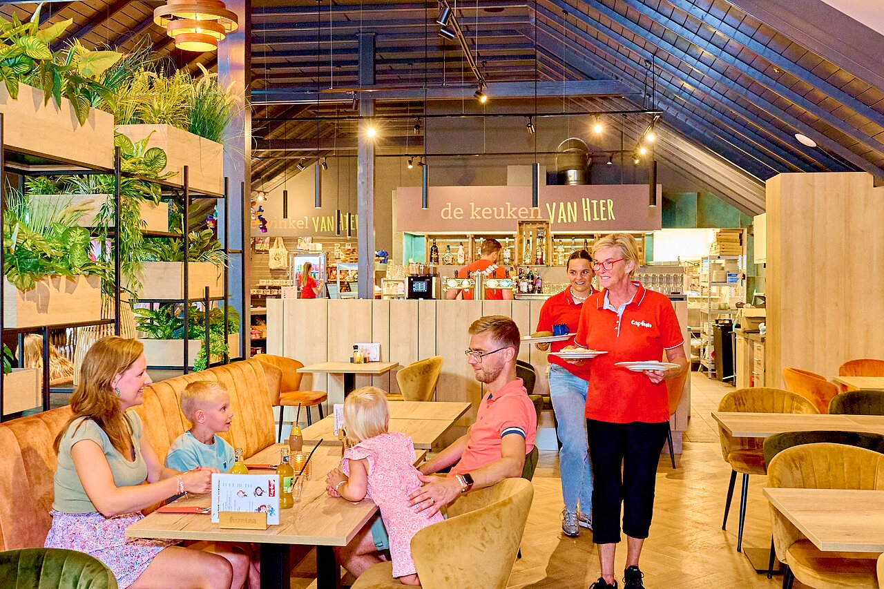 Familie dineert in modern restaurant met bar op camping CAPFUN Wieskamp in Winterswijk Henxel.
