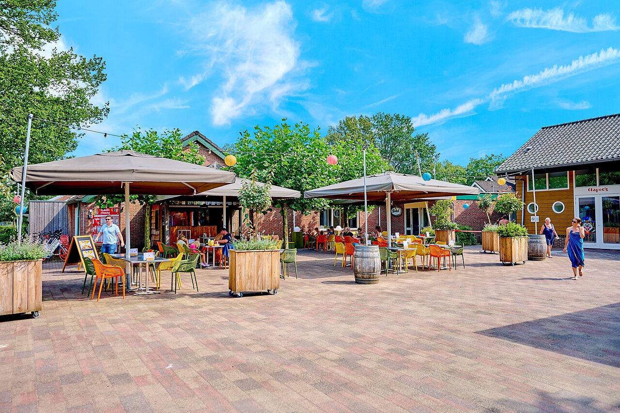 Levendig buitenrestaurant terras met gasten op camping CAPFUN Wieskamp in Winterswijk Henxel.