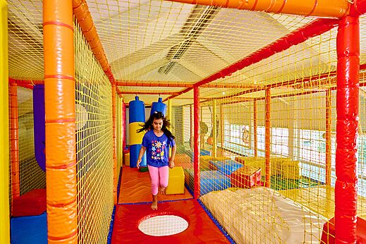 Kleurrijke binnenspeeltuin met kind op camping CAPFUN Wieskamp in Winterswijk Henxel.