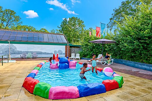 Kleurrijk kinderbad met spelende kinderen op camping CAPFUN Wieskamp in Winterswijk Henxel.
