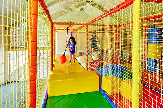 Binnenspeeltuin met kind en schommelbal op camping CAPFUN Wieskamp in Winterswijk Henxel.