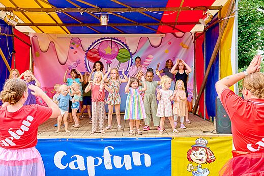 Kinderen nemen deel aan animatie op podium met animatoren op camping CAPFUN Wieskamp in Winterswijk Henxel.