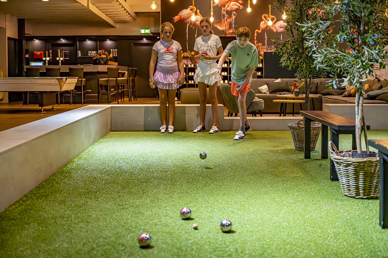 Kinderen spelen jeu de boules op indoorbaan bij camping CAPFUN het Winkel in Winterswijk.