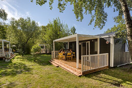 Modern stacaravan met overdekt terras en familie op camping CAPFUN het Winkel in Winterswijk.