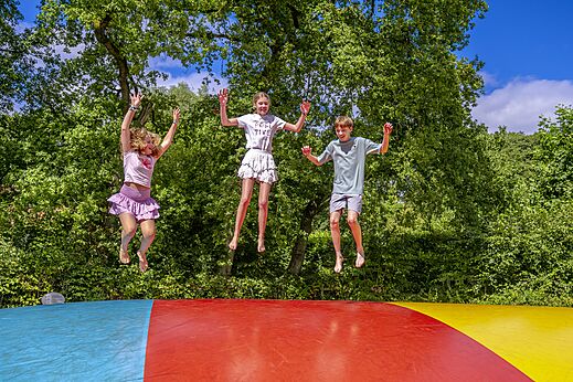 Kinderen springen vrolijk op een springkussen op camping CAPFUN het Winkel in Winterswijk.