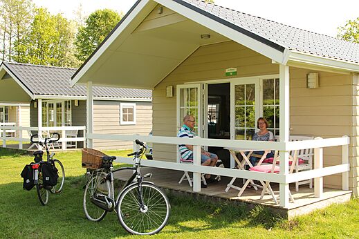 Stacaravan met stel op terras, fietsen, op camping CAPFUN het Winkel in Winterswijk.