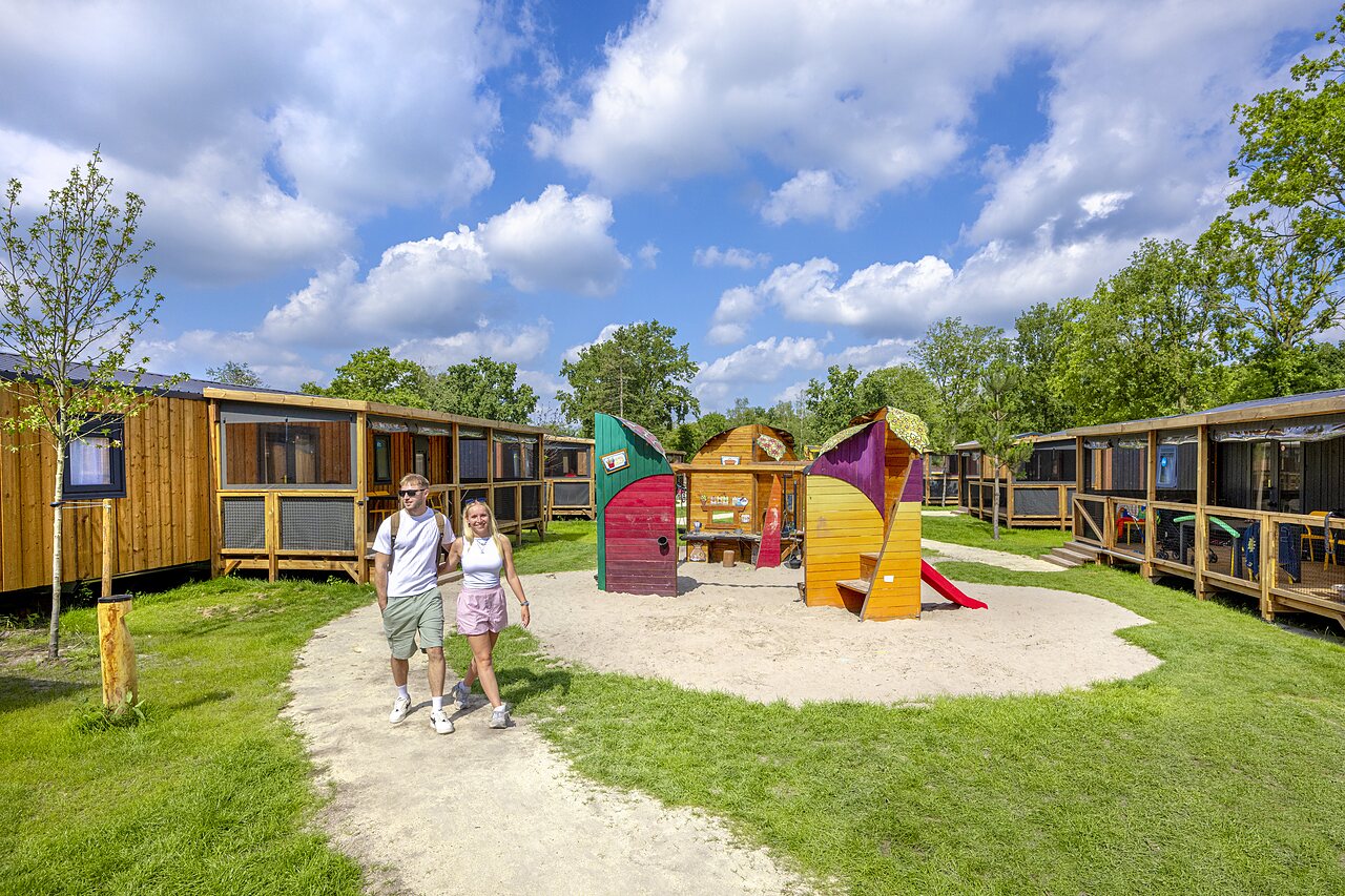 Houten stacaravans en kleurrijke speeltuin op camping CAPFUN de Wondermolen in Molenschot.