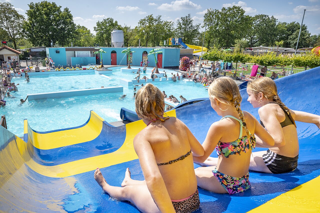 Kinderen op waterglijbaan, levendig buitenzwembad op camping CAPFUN de Wondermolen in Molenschot.