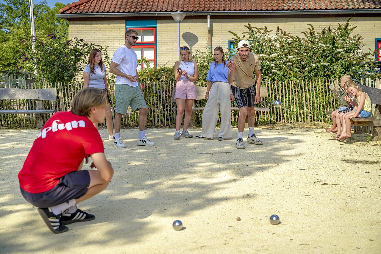 Jongeren spelen jeu de boules op camping CAPFUN de Wondermolen in Molenschot.