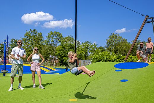Kind op tokkelbaan in de speeltuin van camping CAPFUN de Wondermolen.
