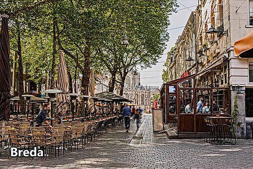 Levendig stadscentrum van Breda met terrassen en historische kerk, Nederland.