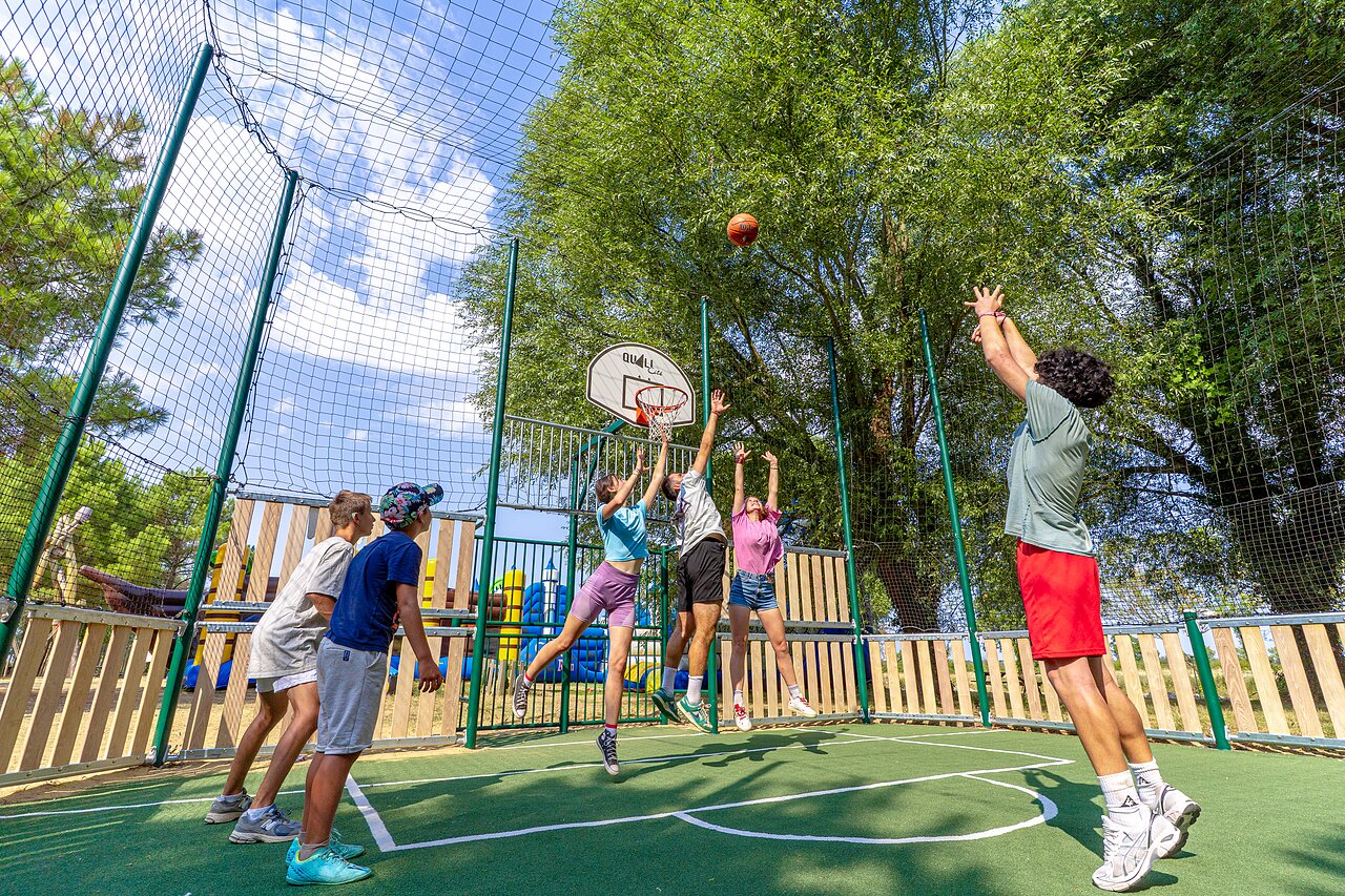 Jongeren basketballen op multisportterrein op camping CAPFUN Zagarella in LONGEVILLE SUR MER (85).