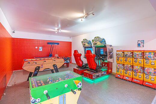 Speelzaal met tafelvoetbal en arcadekasten op camping CAPFUN Zephir in Les Mathes La Palmyre.