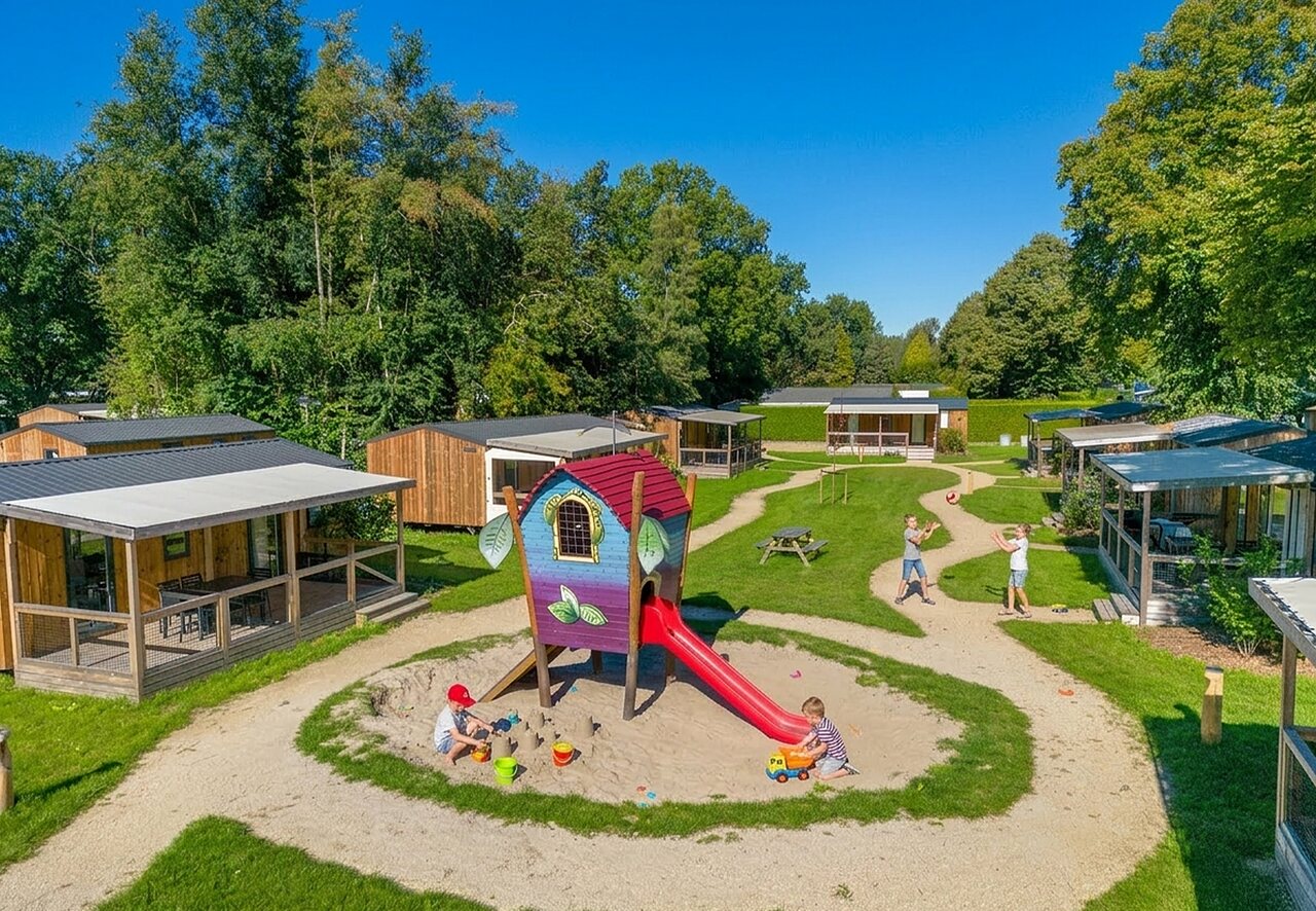 Speeltuin met glijbaan en kinderen, stacaravans op camping CAPFUN Zeumersehof in Voorthuizen.